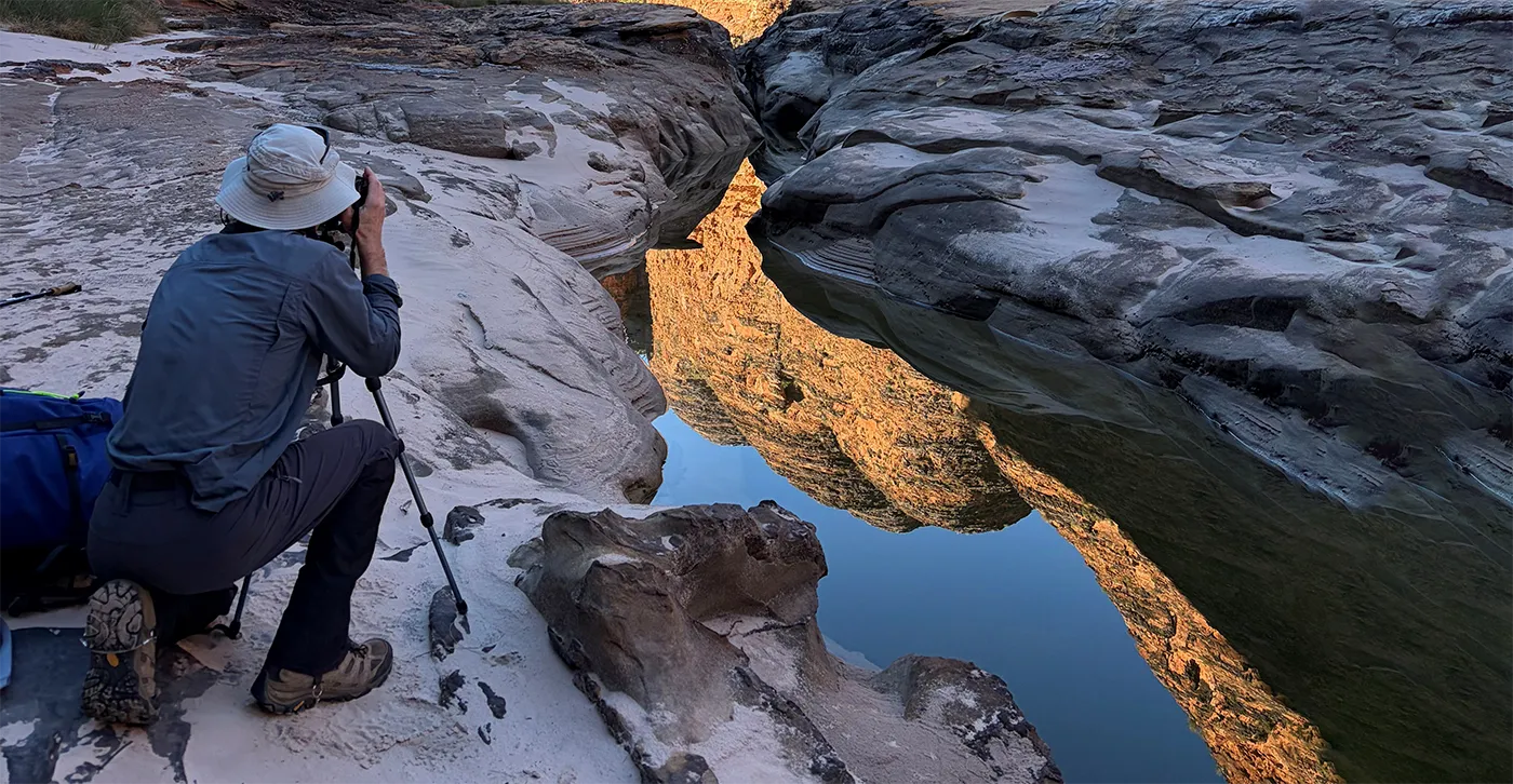 Person taking a professional photo at the bottom of a canyon